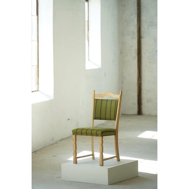 A characterful set of eight Danish dining chairs by Henning Kjærnulf, crafted in oak and dating from the 1960s. The chairs...
