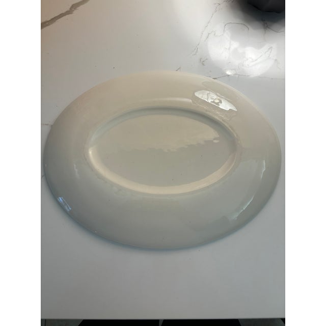 Elegant mid-century modern oval platter featuring a classic atomic starburst motif in warm gold over a soft ivory glaze....