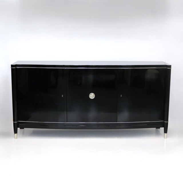 An elegant three-door De Coene Frères Sideboard with a delicate metal profile. The door is adorned with round fittings...