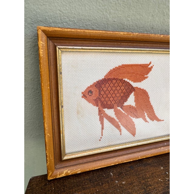 A charming hand-stitched needlepoint of a fantail goldfish rendered in warm terracotta and burnt orange tones on a cream...
