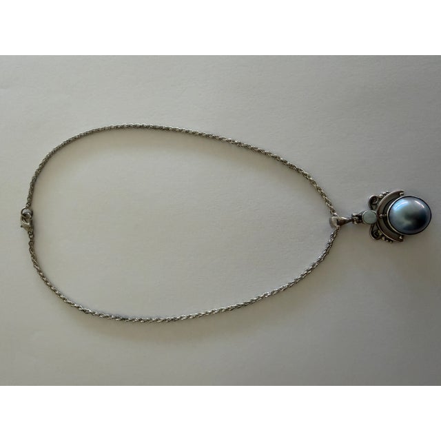 Vintage 925 sterling silver necklace with an artisan sterling silver pendant featuring a prominent, iridescent Mabe pearl...