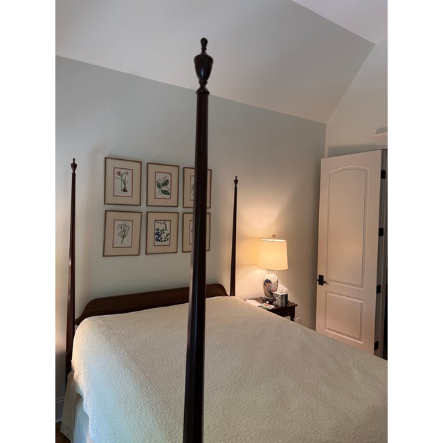 Classic queen-sized pencil post bed by Henkel Harris. Bed features four finial-topped pencil shaped posts and a gently...