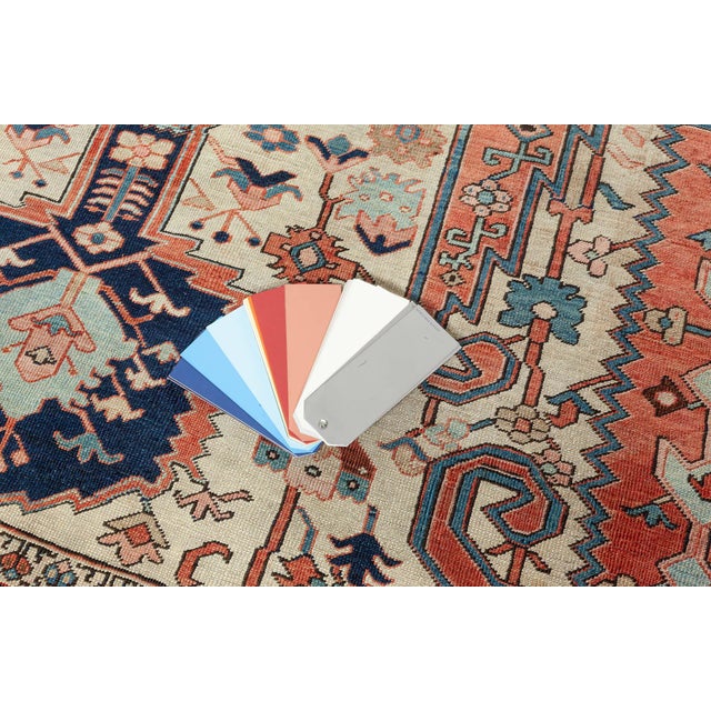 An early 20th century Persian Heriz antique rug displays a symmetrical pattern of botanical motifs, vines and palmettes...