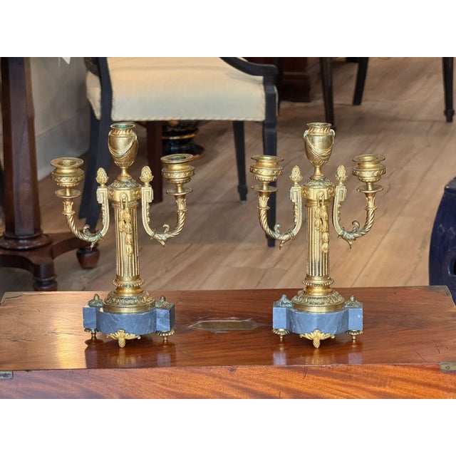 Pair of mid 19th C. French gilt bronze and marble two light candelabra, each with a fluted column hung with a husk swag...