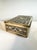 A decorative brass box with a cedarwood core, featuring Art Deco ornamentation with Asian motifs such as elephants,...