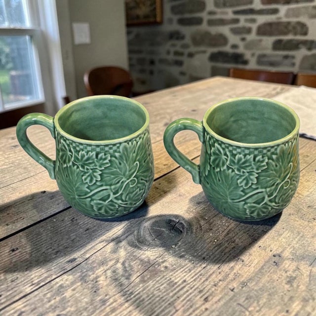 The Vintage Pair Bordallo Pinheiro Portugal Green Vine Leaf Mugs are a charming addition to any kitchen or dining area....