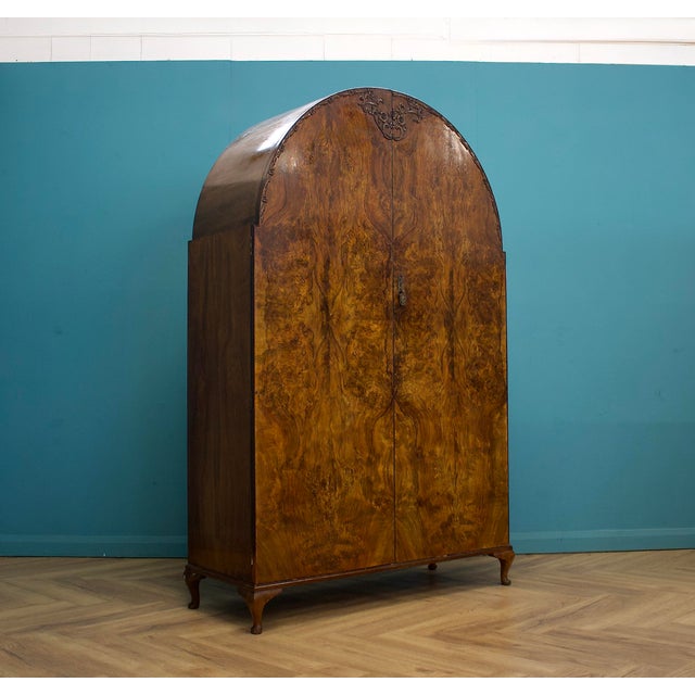 A beautifully figured burr walnut double wardrobe with striking bookmatched veneers and an elegant arched top, finished...