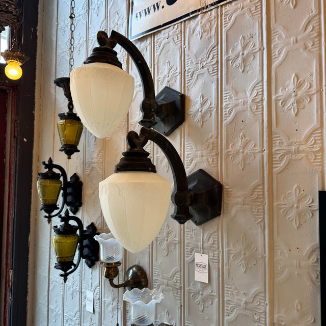 Pair of Original Art Deco exterior wall sconces. Featuring Opal Satin Acorn Glass Shades and Cast Bronze stepped geometric...