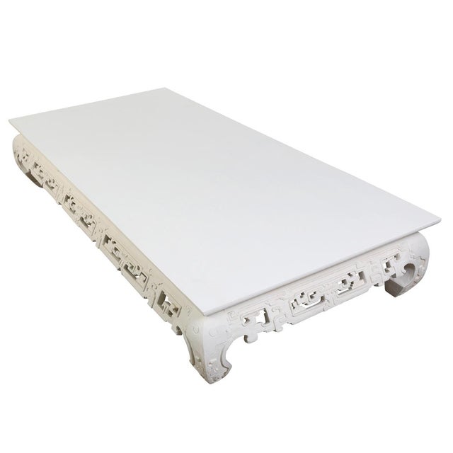 A painted and hand carved Chinese wooden coffee table featuring a beautifully carved apron with intricate geometric...