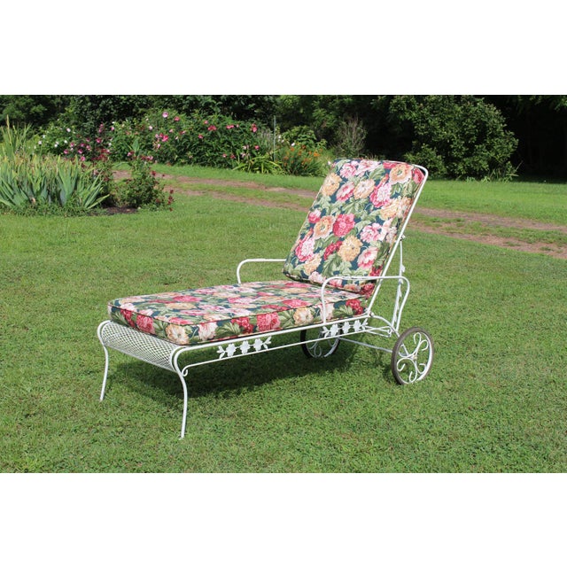 Soak up the sun's warmth as you relax on this retro wrought iron chaise lounge with its two cushions covered in pink and...