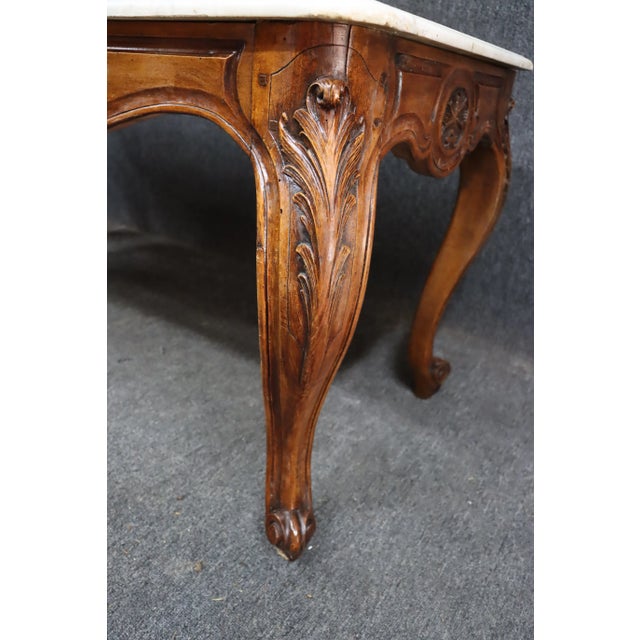 Highly carved Louis XV style Walnut console table with Carrera marble top.
