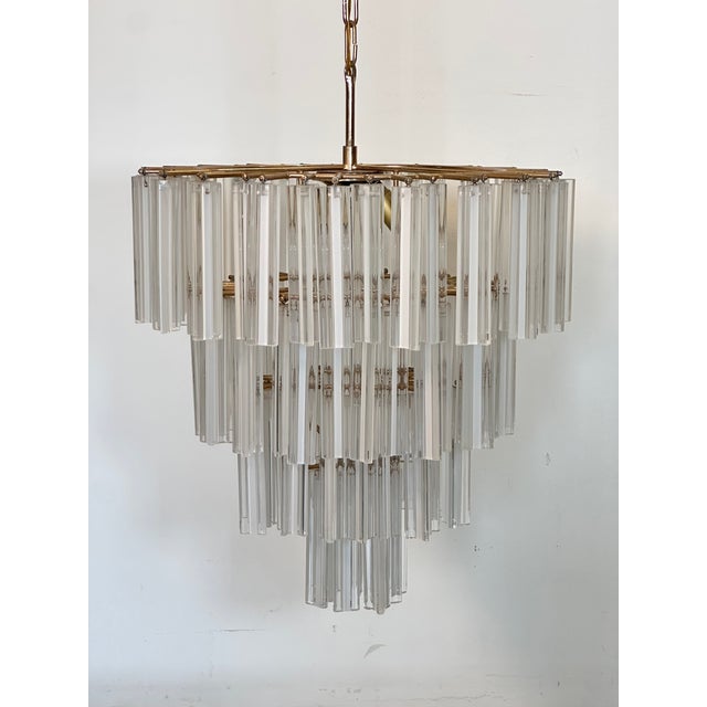 1970s chandelier, brass structure and trilobe pendants in transparent and white Murano glass, the height of the chandelier...
