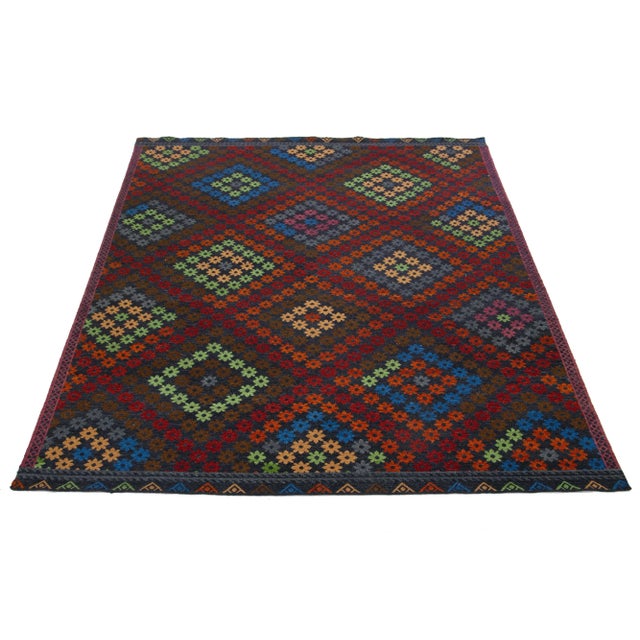 This beautiful modern Soumak hand-knotted wool rug has a dark gray field. It features green, brown, and red accents in a...