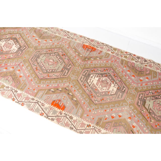 This is a vintage Turkish Oushak rug from the Mid 20th Century. The piece was hand-knotted.