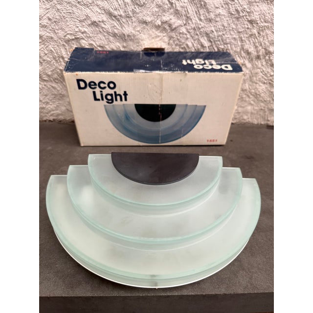 Elco “Deco Light” wall sconce in its original box. The wall light is made of frosted plastic made to look like glass. This...