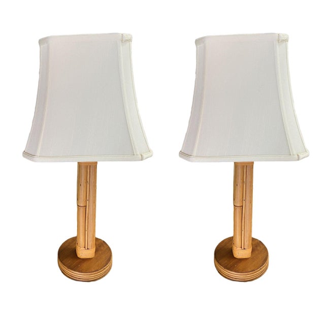 Restored pair of mid-century rattan table lamps featuring eight decorative rattan poles fixed to a round mahogany base...