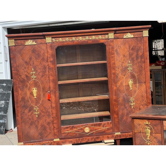 Elegant French Louis XVI style bookcase cabinet crafted in richly figured flame mahogany, adorned with finely cast ormolu...