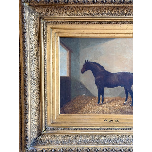 A charming 19th century equestrian portrait depicting a dark bay horse identified as “Wildfire,” standing within the quiet...