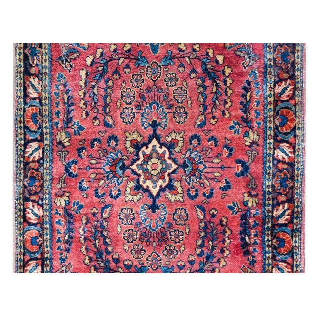 A wonderful early 20th century Persian Sarouk rug with a traditional mirrored floral cluster pattern woven in light and...