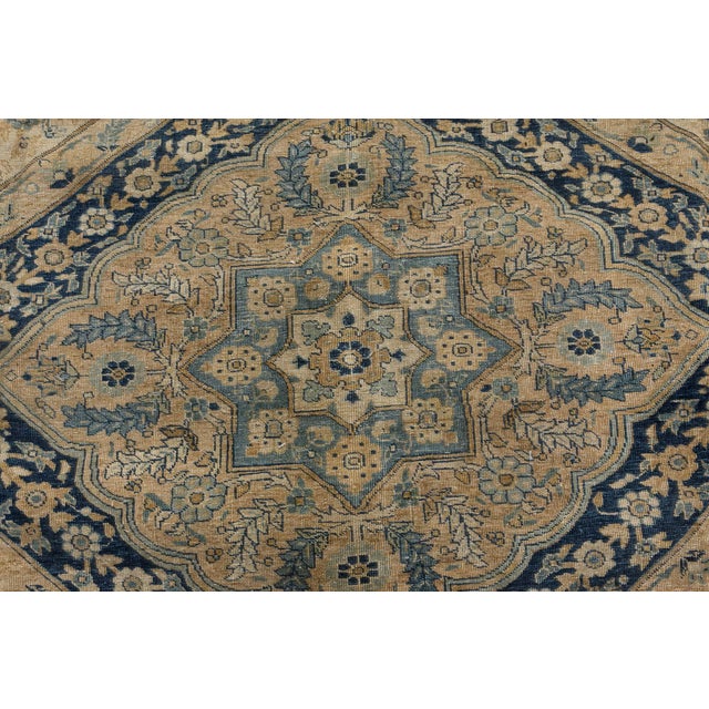 An early 20th century Persian Tabriz carpet, the three sand-colored linked medallions containing stellar medallions and...