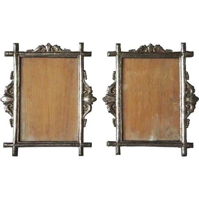 Found in Goa, India, this lovely pair of antique frames was hand fashioned with silver overlay on hand carved teak bases....
