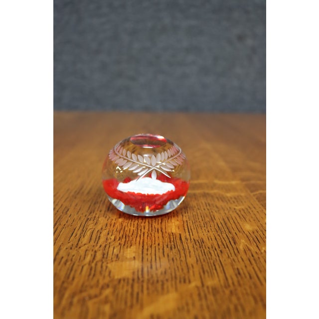 Heavy art glass paperweight featuring a ruby red overlay with hand-cut laurel wreath and cross surrounding a frosted...