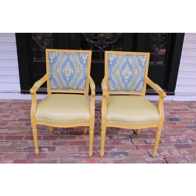 A beautiful pair of Palecek chairs upholstered in a light butter yellow leather with a blue and green fabric seat back. In...