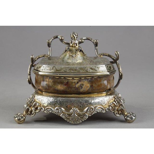 Inkwell in agate set in a vermeil mount. The agate cut is closed by a finely chiseled lid of foliage patterns and whose...