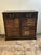 Handsome vintage cabinet clad in tooled leather on the top and the sides, having two doors featuring faux book fronts, the...