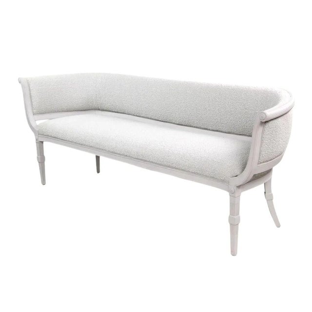 An elegant Gustavian style settee featuring a gracefully curved, fully upholstered boucle back, generous seat cushion, and...