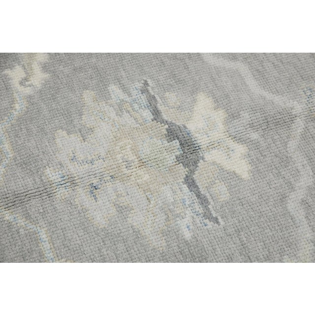 This modern Turkish Oushak rug is a stunning piece of art that has been handwoven using traditional techniques by skilled...