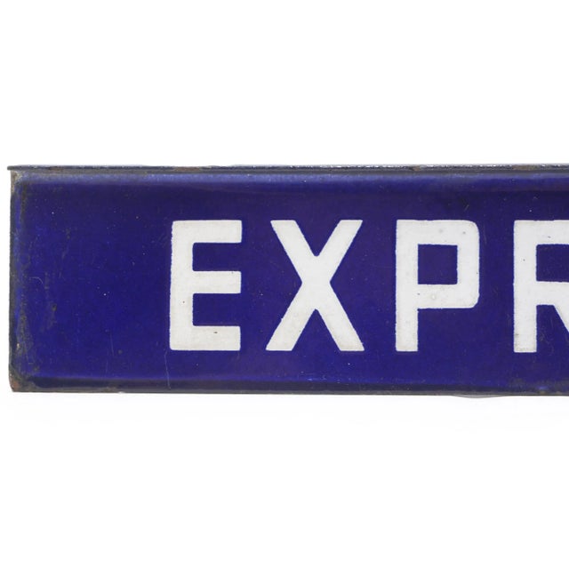 This sign reads, "Express". This rectangular sign is made of steel with white lettering and a blue background. It features...