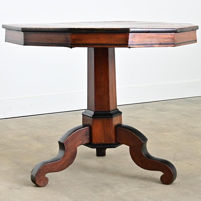 A spellbinding Italian tilt-top table whose geometric surface is a meticulous arrangement of inlaid mahogany, ebonized...