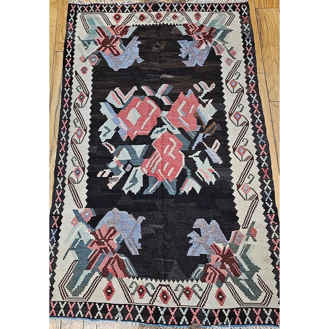 A vintage Karabagh kilim with a single flower bouquet in the field and variations of flower designs in the four corners...