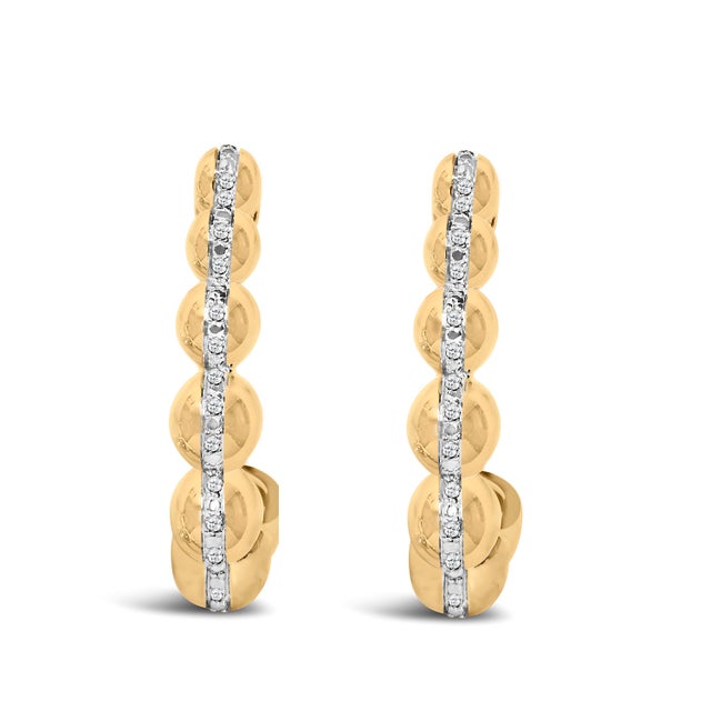 Bold yet refined, these hoops sculpt the ear with a procession of rounded, domed stations that bloom into a scalloped...