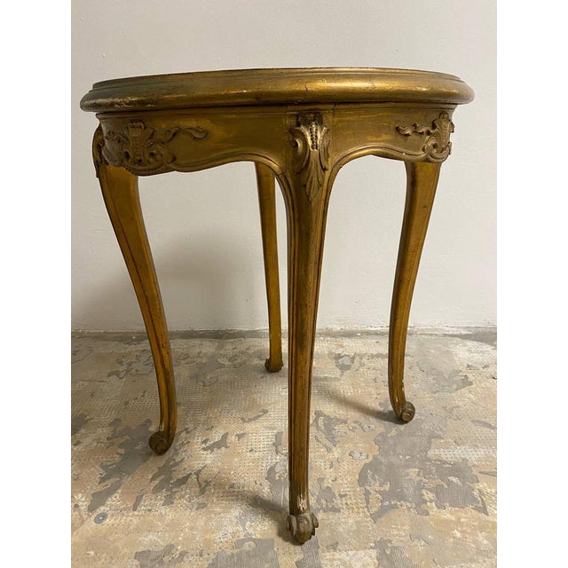 This enchanting "imperial" coffee table features a round top and finely carved legs, embellished with a golden finish that...