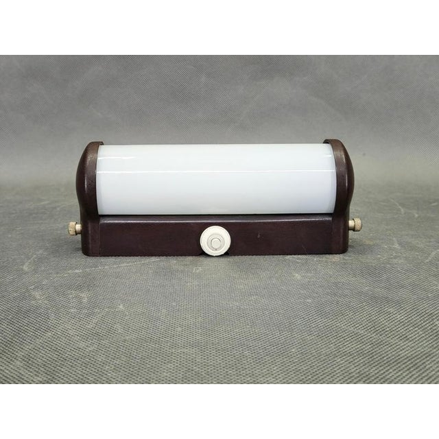 Elegant art deco wall light produced in czechoslovakia during the 1940s featuring a dark bakelite structure paired with a...