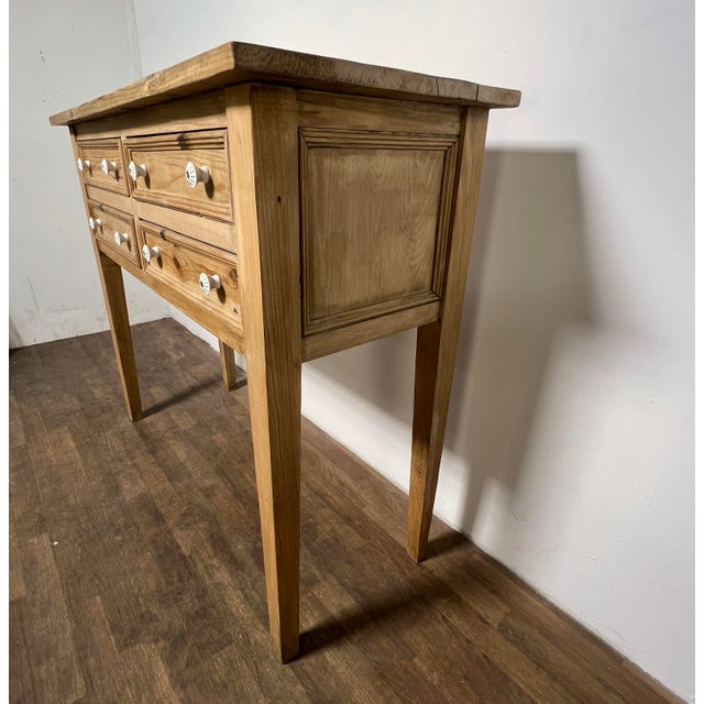 A rustic 20th century French country buffet table in stripped pine with four beaded drawers and porcelain pulls.