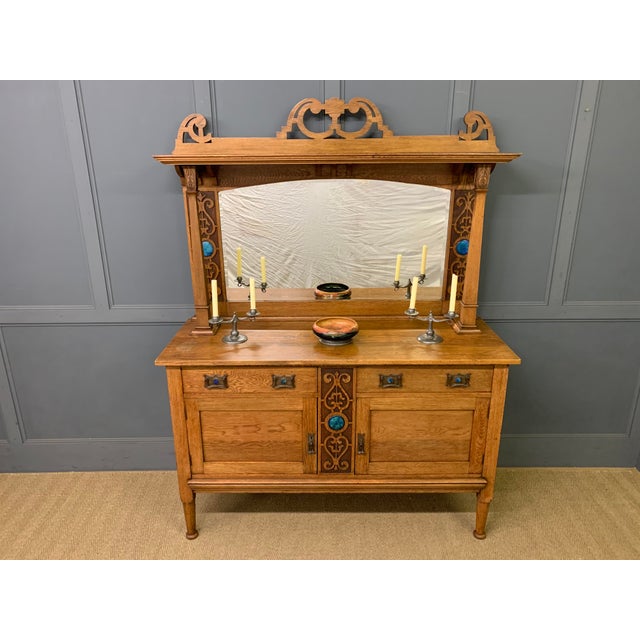 A charming Arts & Crafts period oak mirror backed sideboard. Very well constructed in solid English oak. The top section...