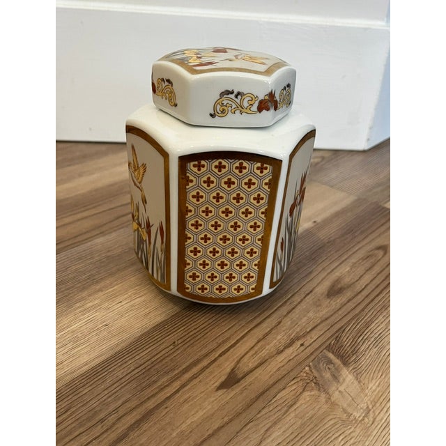 This is a vintage Japanese porcelain hexagonal ginger jar featuring a gold-trimmed hummingbird and iris flower motif with...