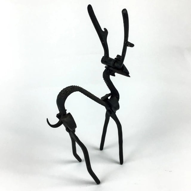 A super cool heavy wrought iron black deer sculpture made from pliers, an old shaver and some other parts. This deer will...