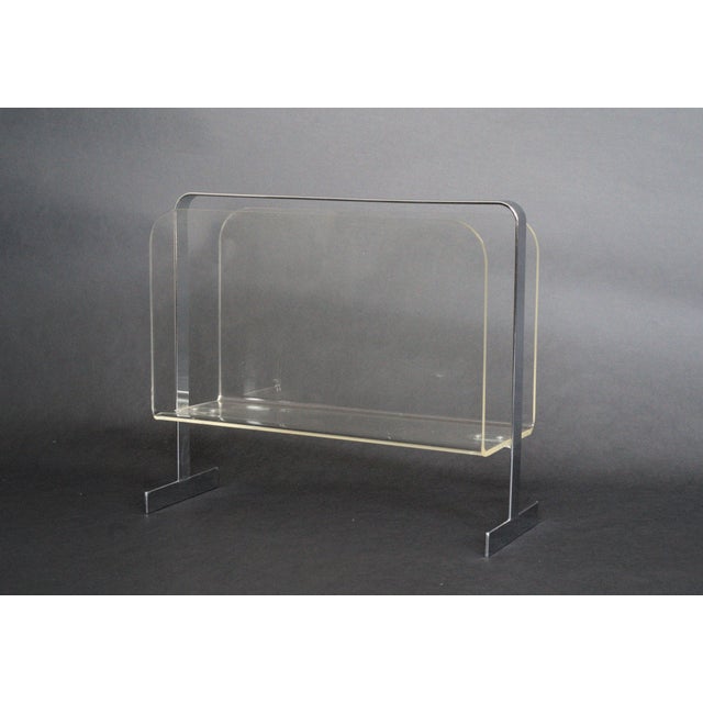 Lucite and chrome magazine rack in the style of Milo Baughman with a sleek and modern design.