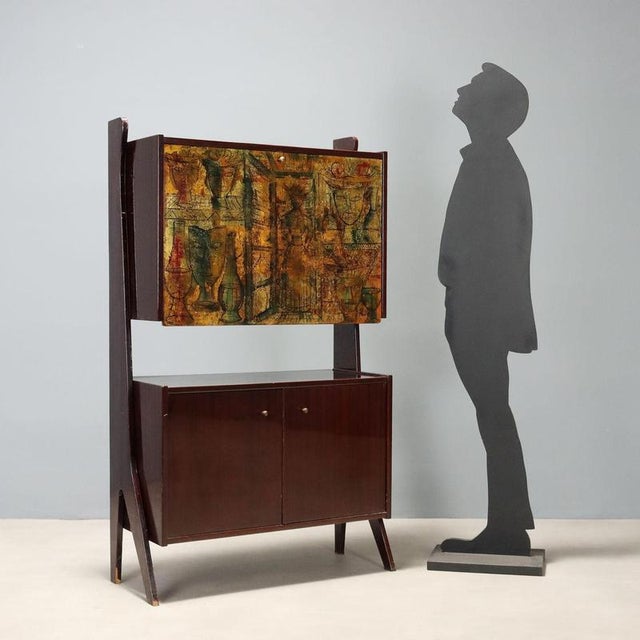 1960s bar cabinet in mahogany veneer, featuring a polyester finish that enhances the wood's natural grain. The top section...