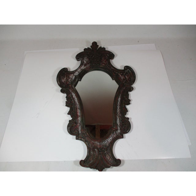Vintage Venetian style Italian mirror made by Palladio. The frame has a walnut finish with maroon rub thru and a cream...