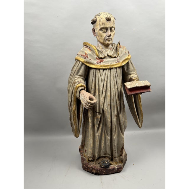 A polychrome carved oak statue from the 18th century depicting Saint Dominic, dressed in a flowing monastic habit. The...