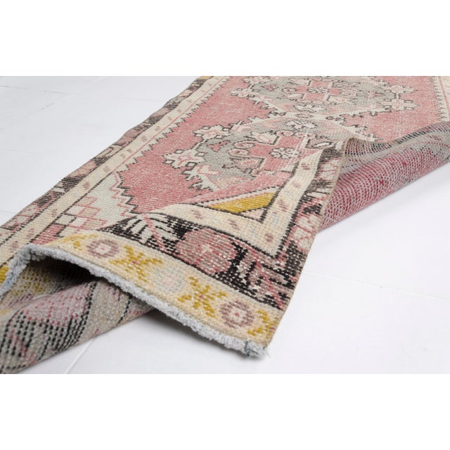 This is a vintage Turkish Oushak rug from the Mid 20th Century. The piece was hand-knotted.