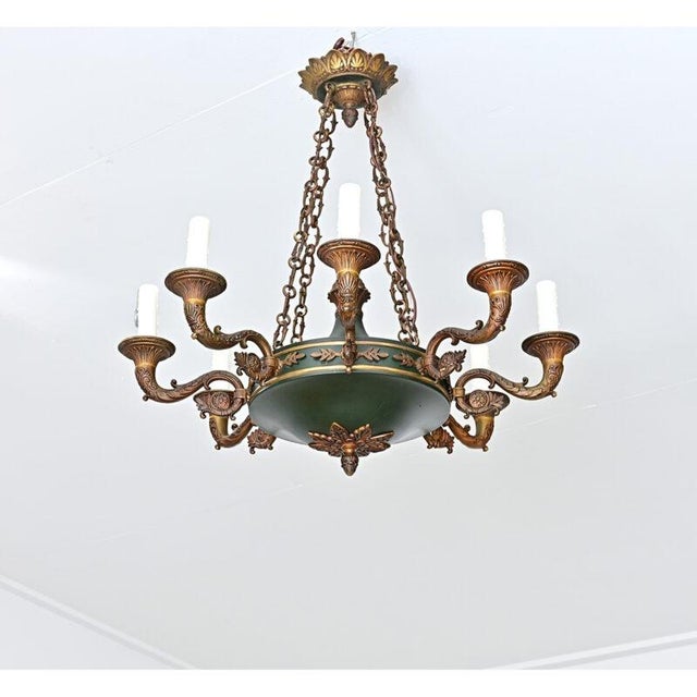 French, 20th century Empire-style ceiling fixture of green tôle using eight candelabra lights to illuminate the stunning...