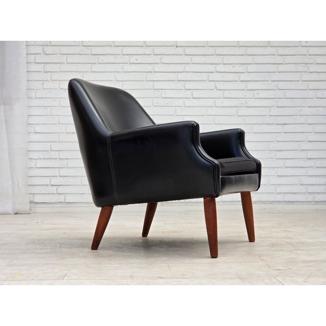 1970s, Danish armchair. Black artificial leather, teak wood legs, seat cushion in furniture wool. Original good condition:...