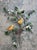 A charming vintage handcrafted metal wall sculpture depicting two golden songbirds perched among flowering branches and...