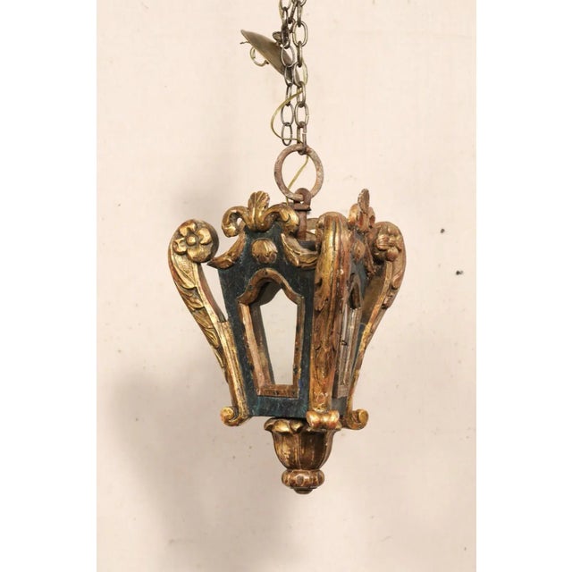 An Italian single-light carved and painted wood hanging lantern from the 19th century. This antique hanging light fixture...